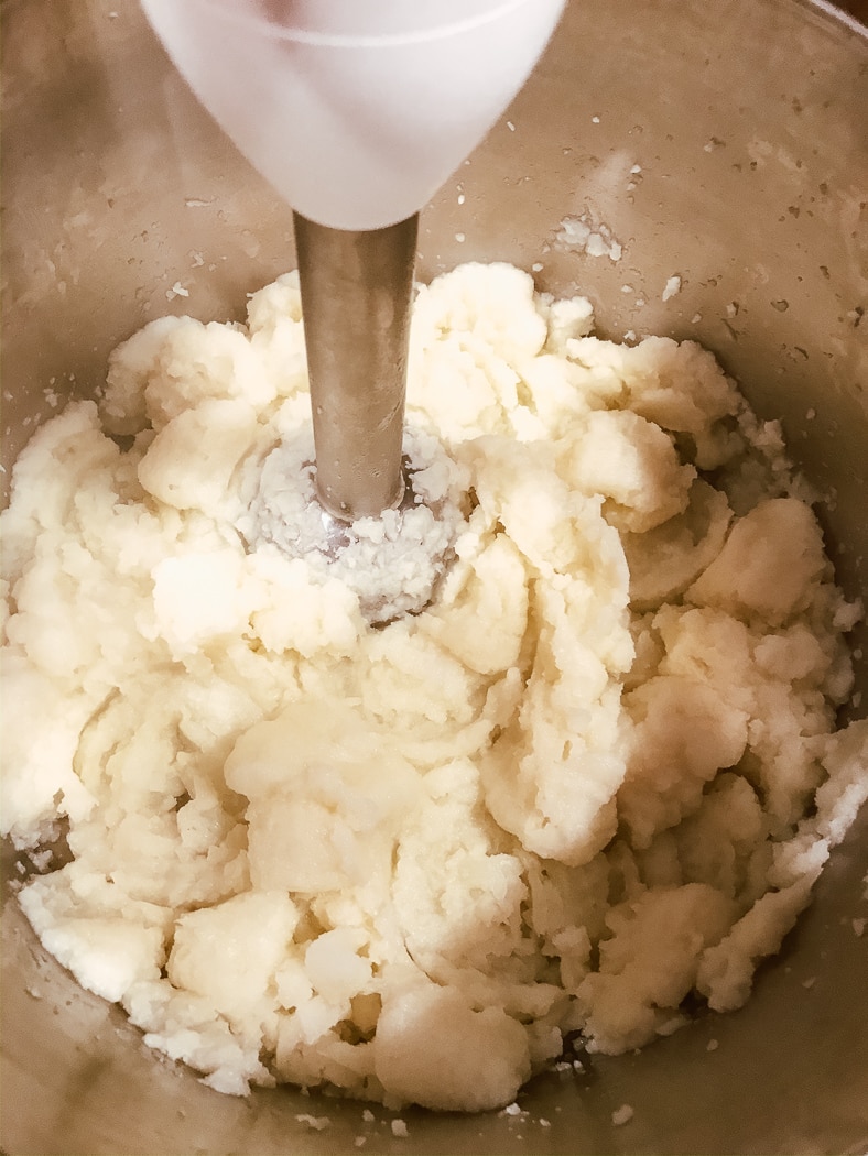 An immersion blender blending up boiled cauliflower.