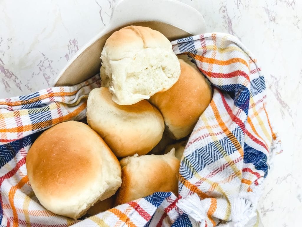 A basket filled with warm Parker house rolls.