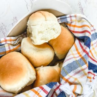 A basket filled with warm Parker house rolls.