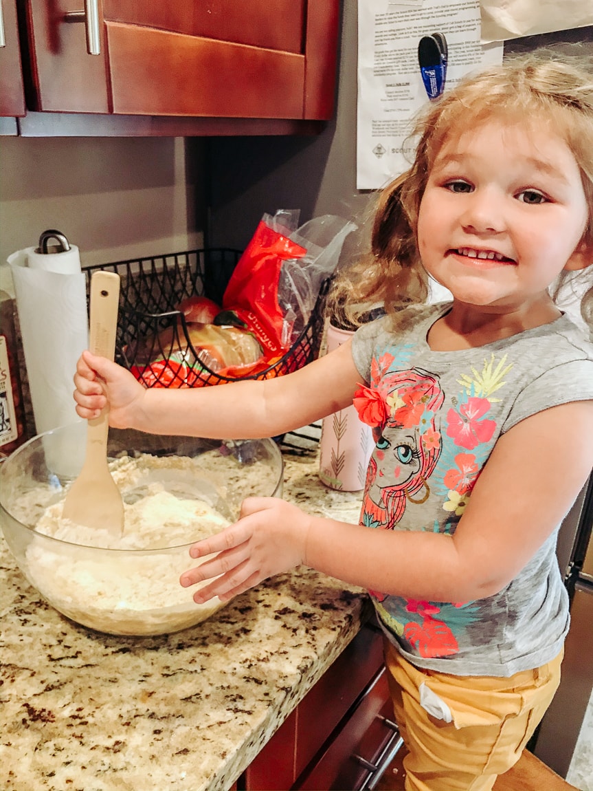Little girl mixing pumpkin cornbread muffin batter.