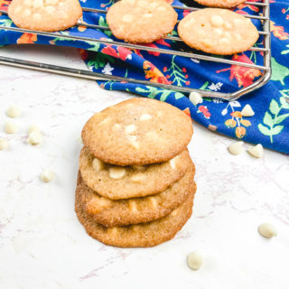 A cooling rack of cookies next to a stack of salted caramel cookies.