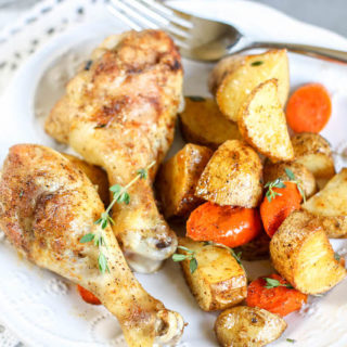 A plate of chicken, carrots, and potatoes.