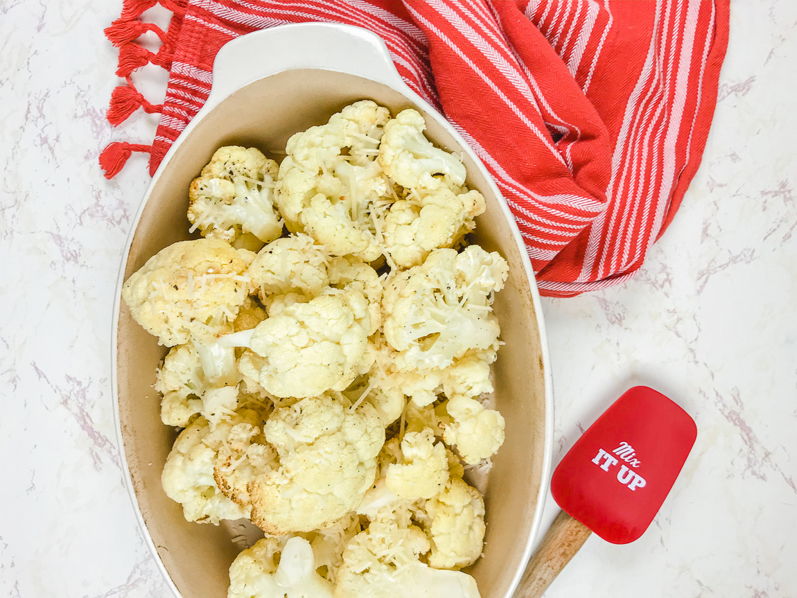 Red striped towel next to dish of air fried cauliflower.