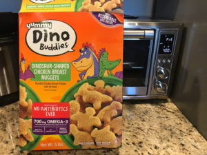Box of Dino nuggets in front of air fryer oven.