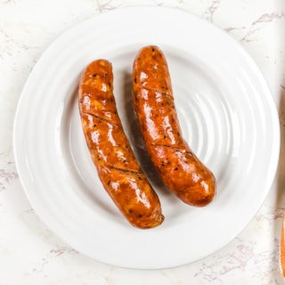 A white plate with two air fried sausage.