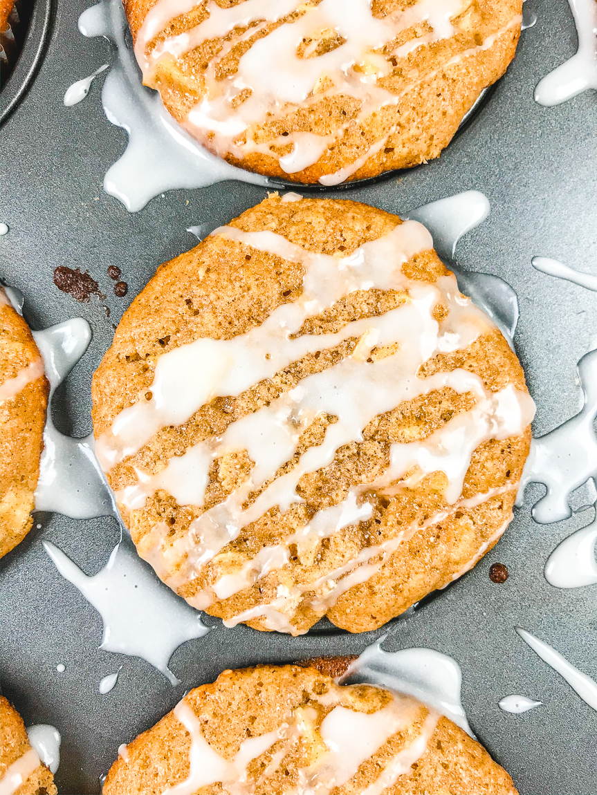 Close up of apple cinnamon muffin with icing drizzled on top.