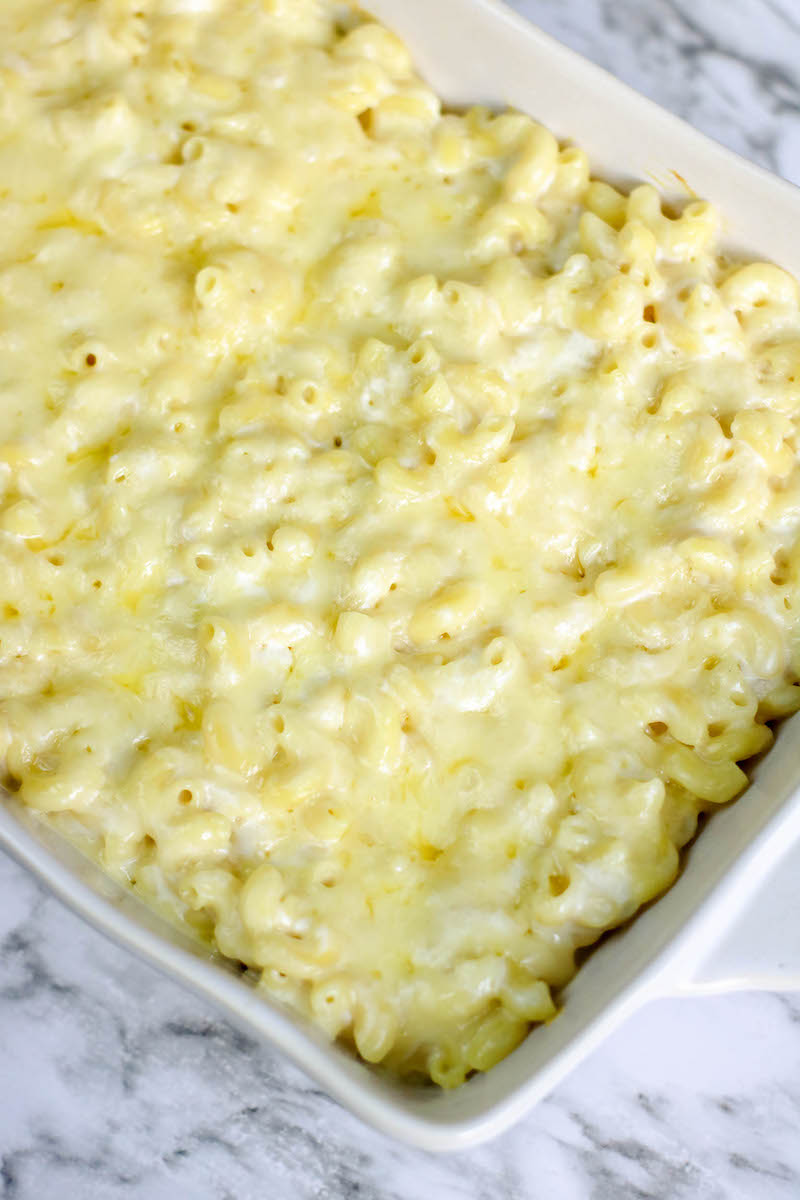 A casserole dish filled with baked white cheddar mac and cheese.