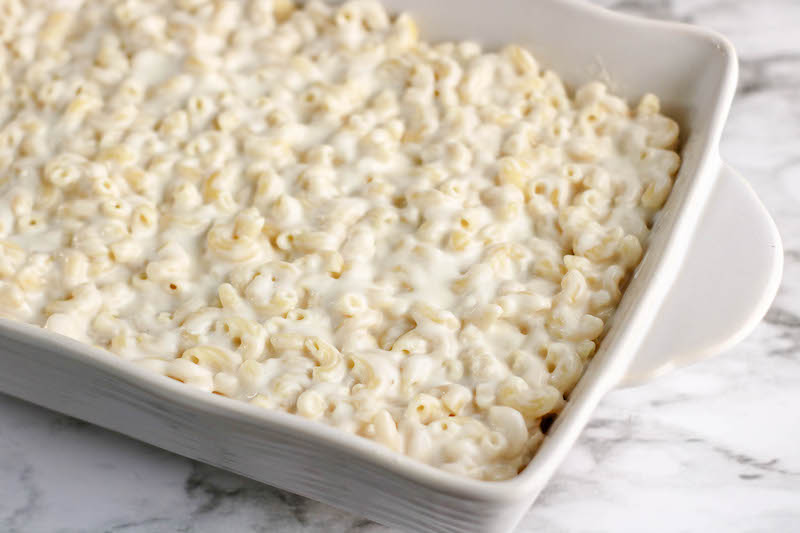 A white casserole dish filled with macaroni and cheese.