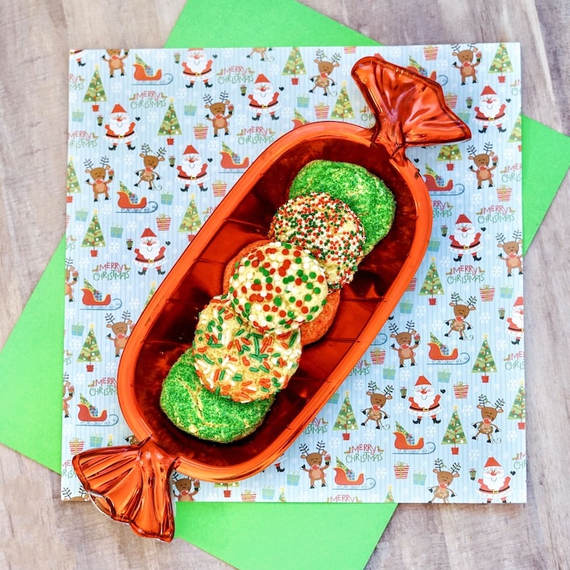 Square photo of christmas cake mix cookies on a Santa patterned napkin.