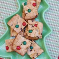 A tree shaped dish filled with Christmas cookie bars.
