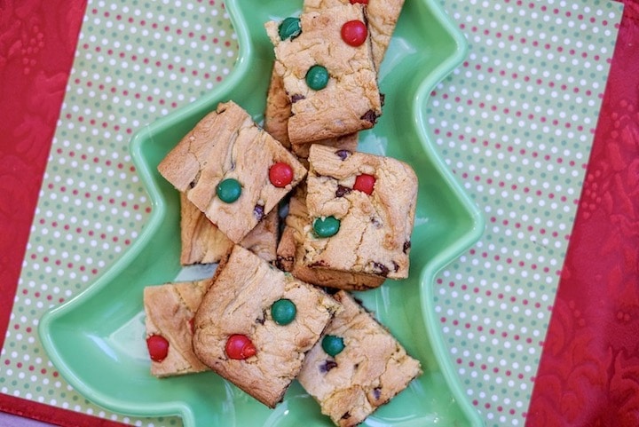 A tree shaped dish filled with Christmas cookie bars.