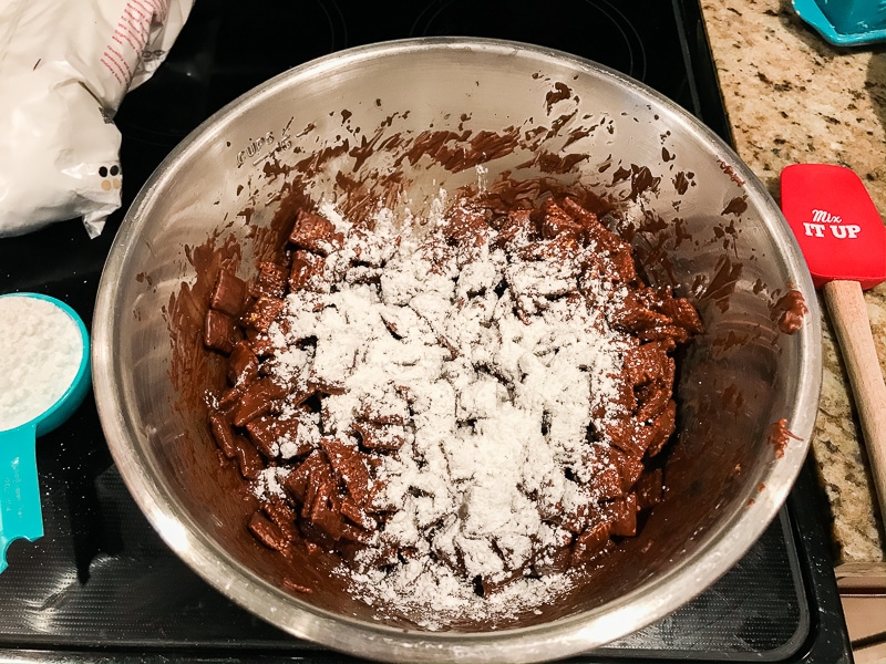 Powdered sugar on top of chocolate coated Chex cereal.