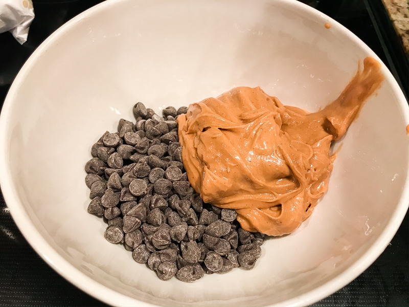 Peanut butter and chocolate chips in a white bowl.