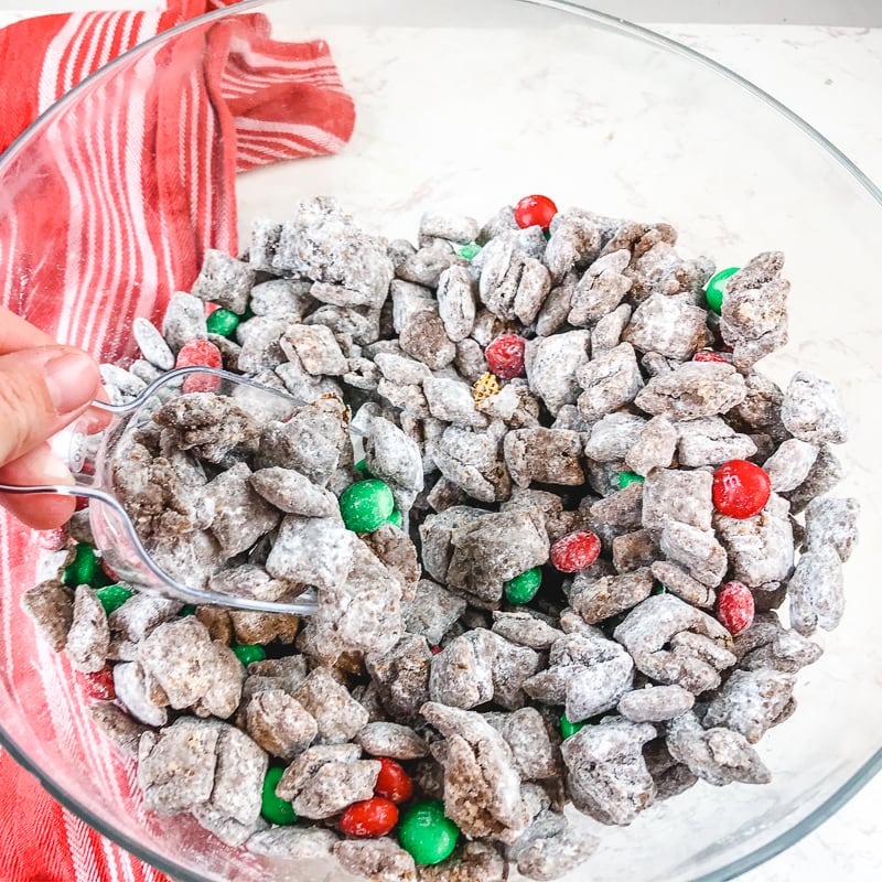 A clear bowl filled with christmas puppy chow.
