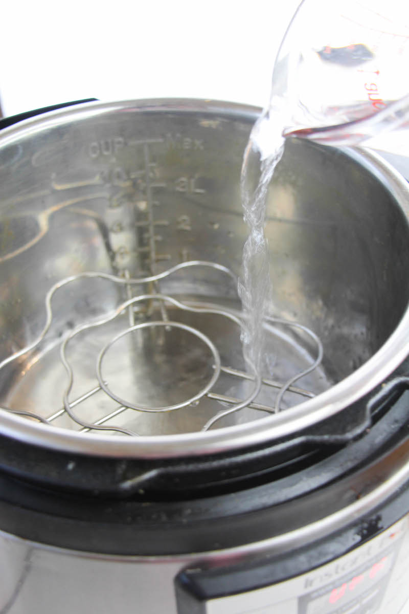 Water being poured into instant pot with trivet.