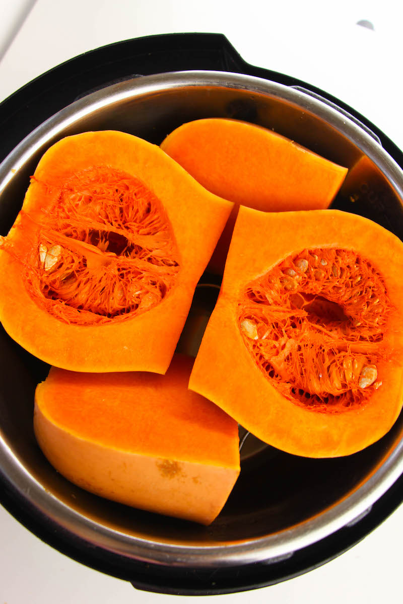 An instant pot filled with quartered butternut squash.