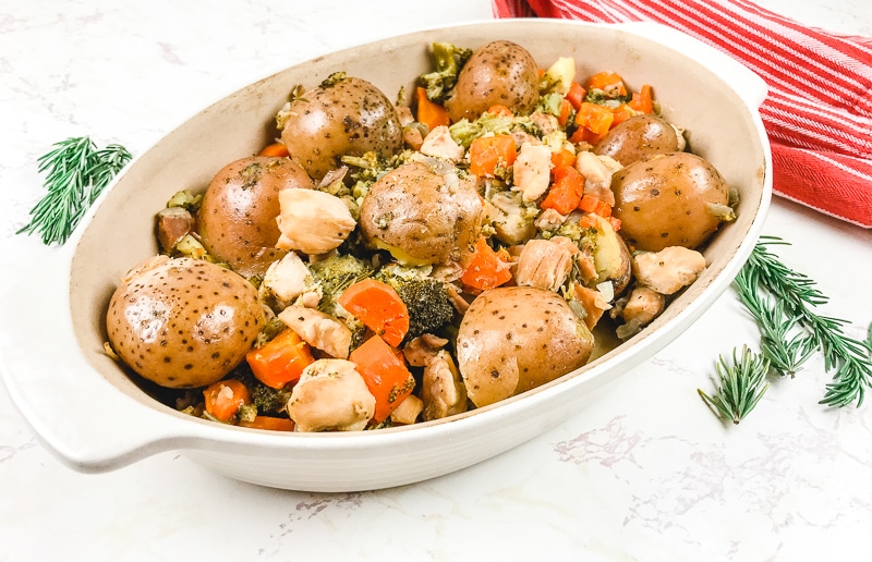 Side view of instant pot chicken and vegetables in oval serving dish.