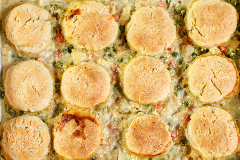 Overhead shot of rectangular baking dish filled with chicken pot pie topped with biscuits.