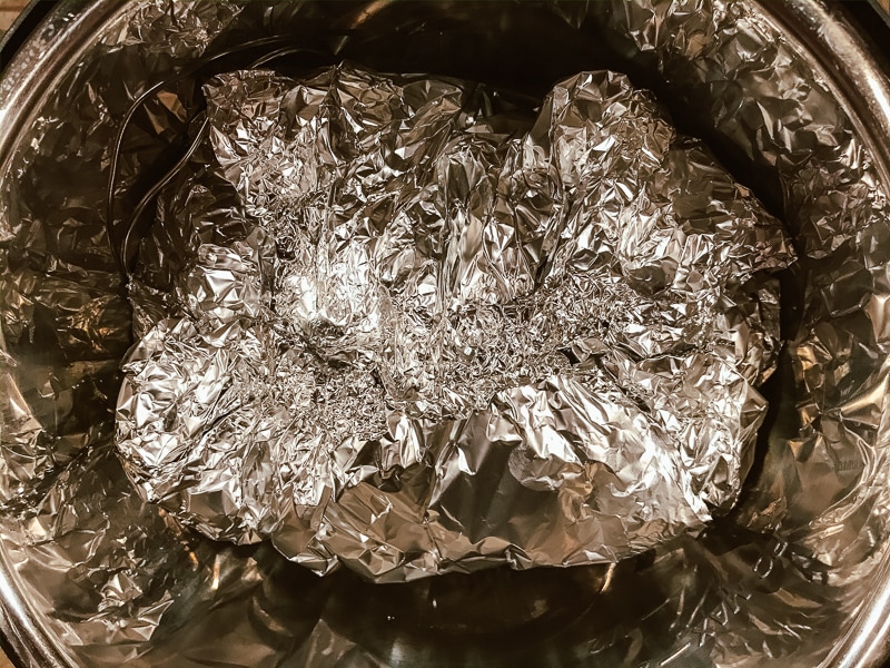 Ham wrapped in foil inside instant pot.