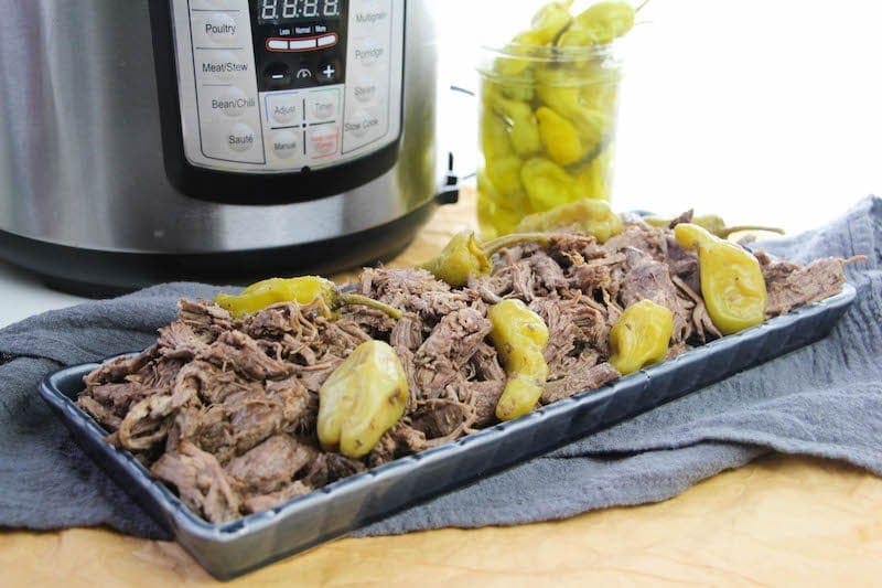 A platter of Italian beef in front of instant pot.