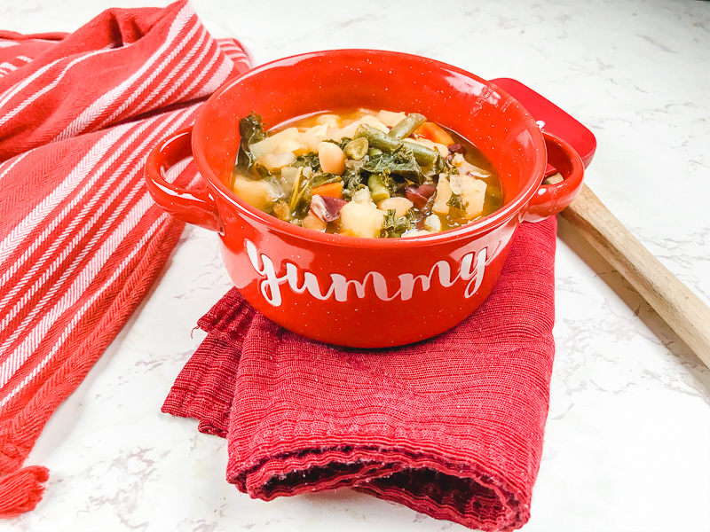 A bowl of soup on top of a folded cloth napkin.