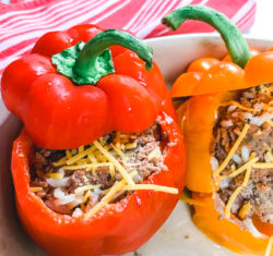 A red bell pepper stuffed with cooked ground beef and topped with cheese.