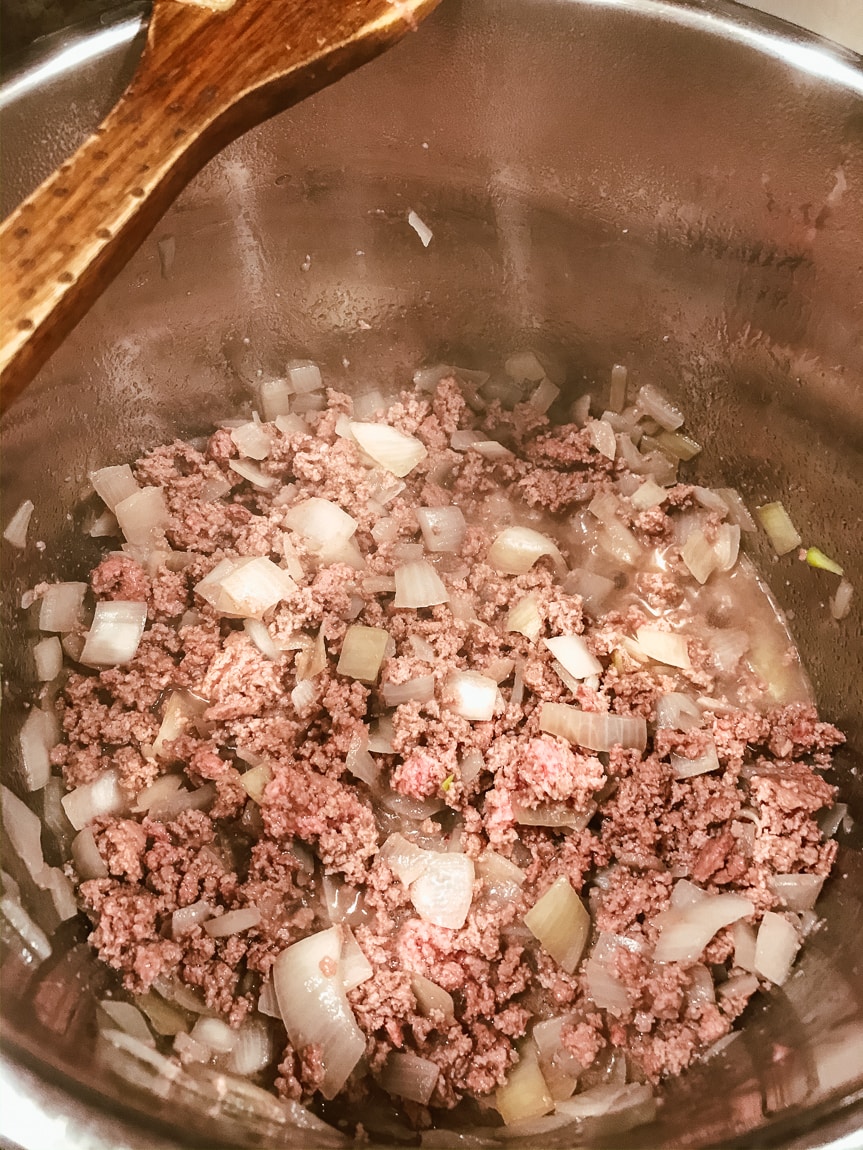 Ground beef being browned inside of instant pot.
