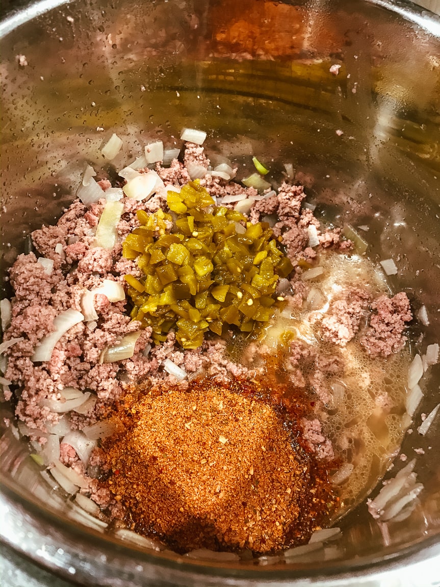 Broth, taco seasoning, chilies, and beef inside instant pot.