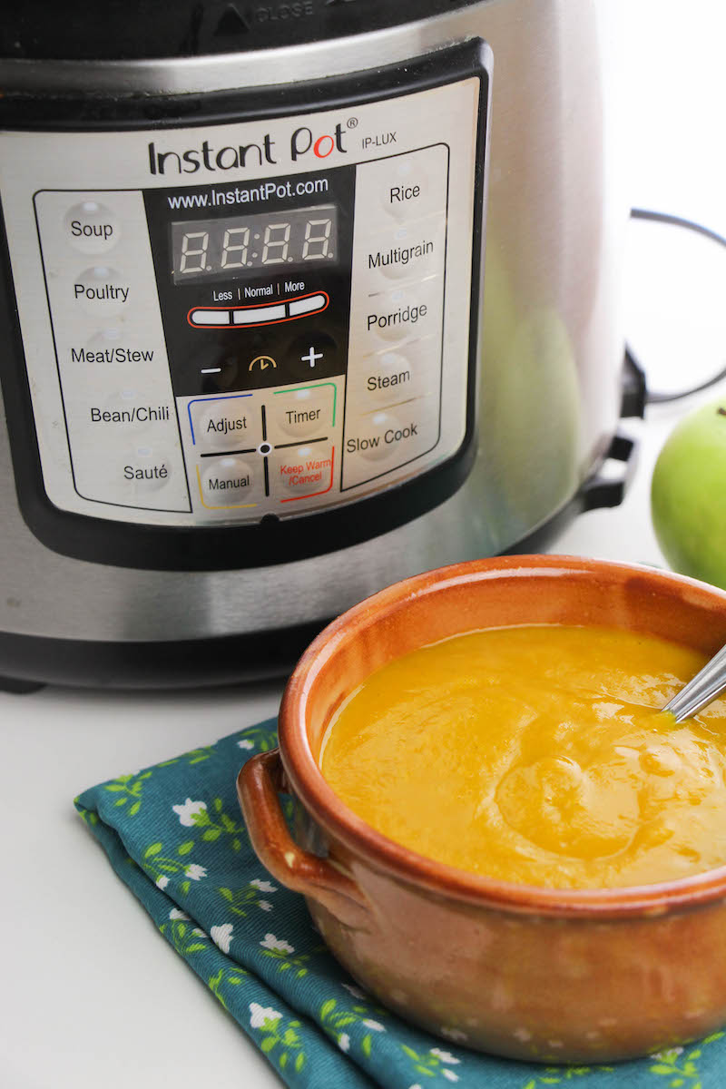 An instant pot with bull of soup in front of it.