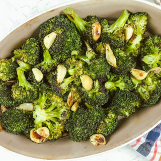 Overhead shot of roasted broccoli and garlic in oval baking dish.