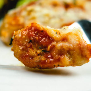 Close up of bite of chicken parmesan.