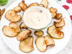 Apple chips on a plate with peanut butter dip.