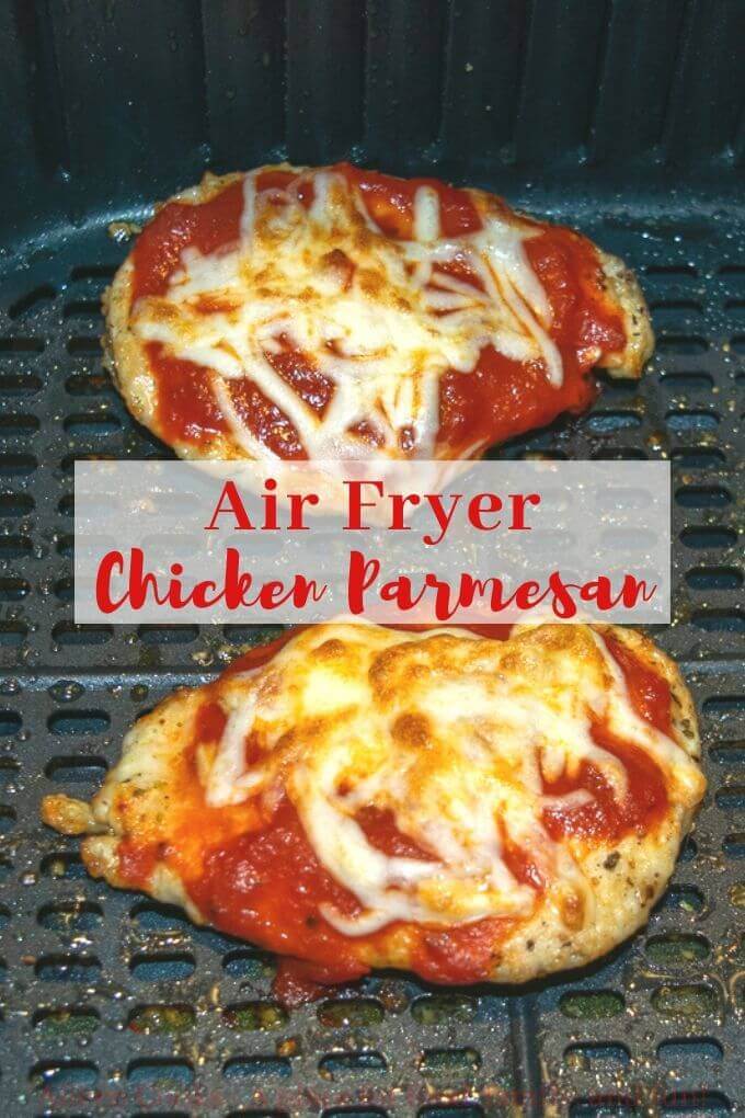 Two slices of chicken parmesan in an air fryer with words "air fryer chicken parmesan" in red letters.