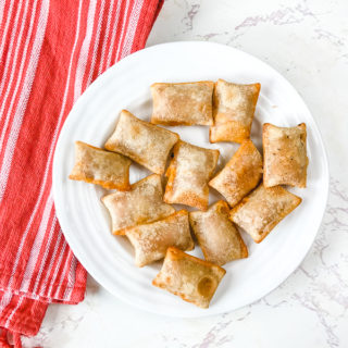 A white plate with air fried pizza rolls.