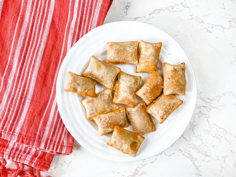 A white plate with air fried pizza rolls.