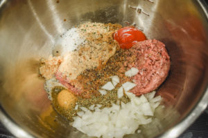 Ingredients for meatloaf in a metal bowl.