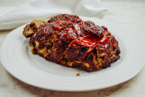 Cooked meatloaf on a white plate.
