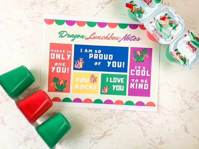 Printable lunchbox notes next to a package of snack packs other side showing their red and green colors.