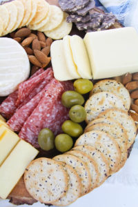 Olives and almonds on charcuterie board.
