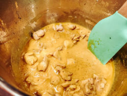 Spoon stirring curry sauce into instant pot.