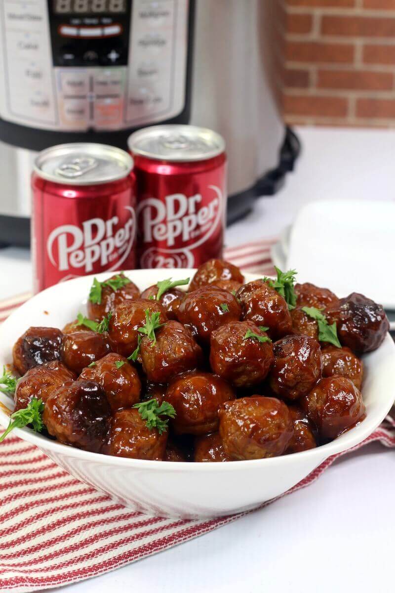 A red striped towel under a bowl filed with dr. pepper meatballs.