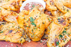 Freshly made wings on a platter with barbecue sauce.