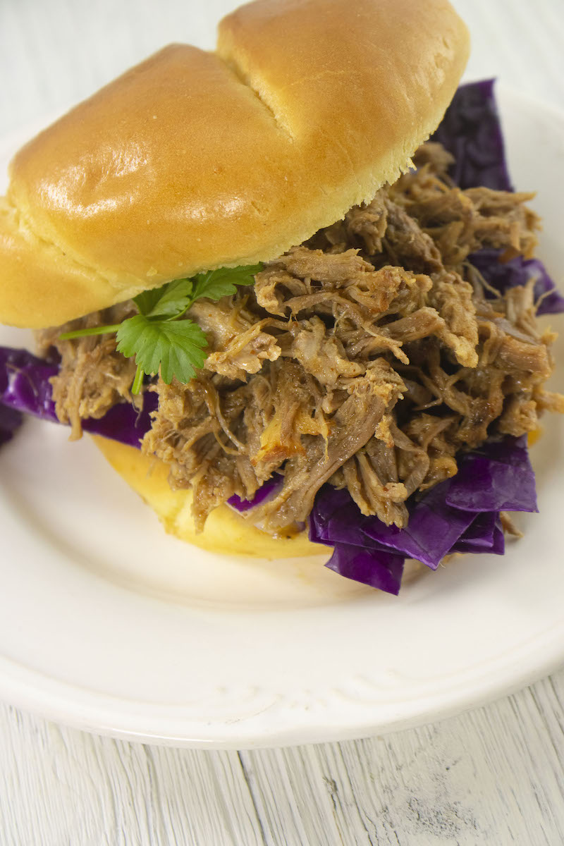 Overhead shot of instant pot pulled pork on a white plate.