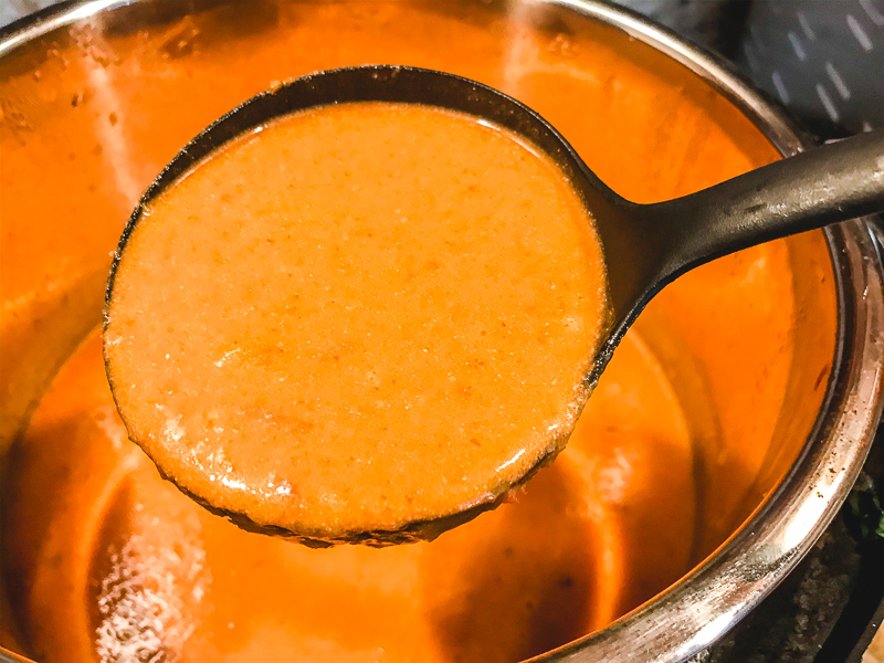 A ladle full of instant pot tomato soup.