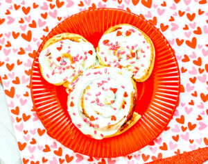 A red plate with a Mickey shaped cinnamon roll