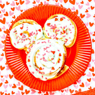 A red plate with a Mickey shaped cinnamon roll