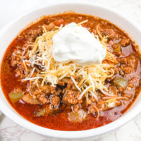 Close up of no bean chili topped with sour cream.