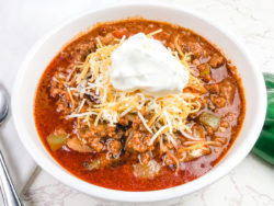 Close up of no bean chili topped with sour cream.