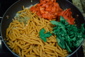 Pasta, basil, tomato, in a large skillet.