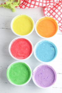 6 bowls of pancake batter, each dyed a different color.